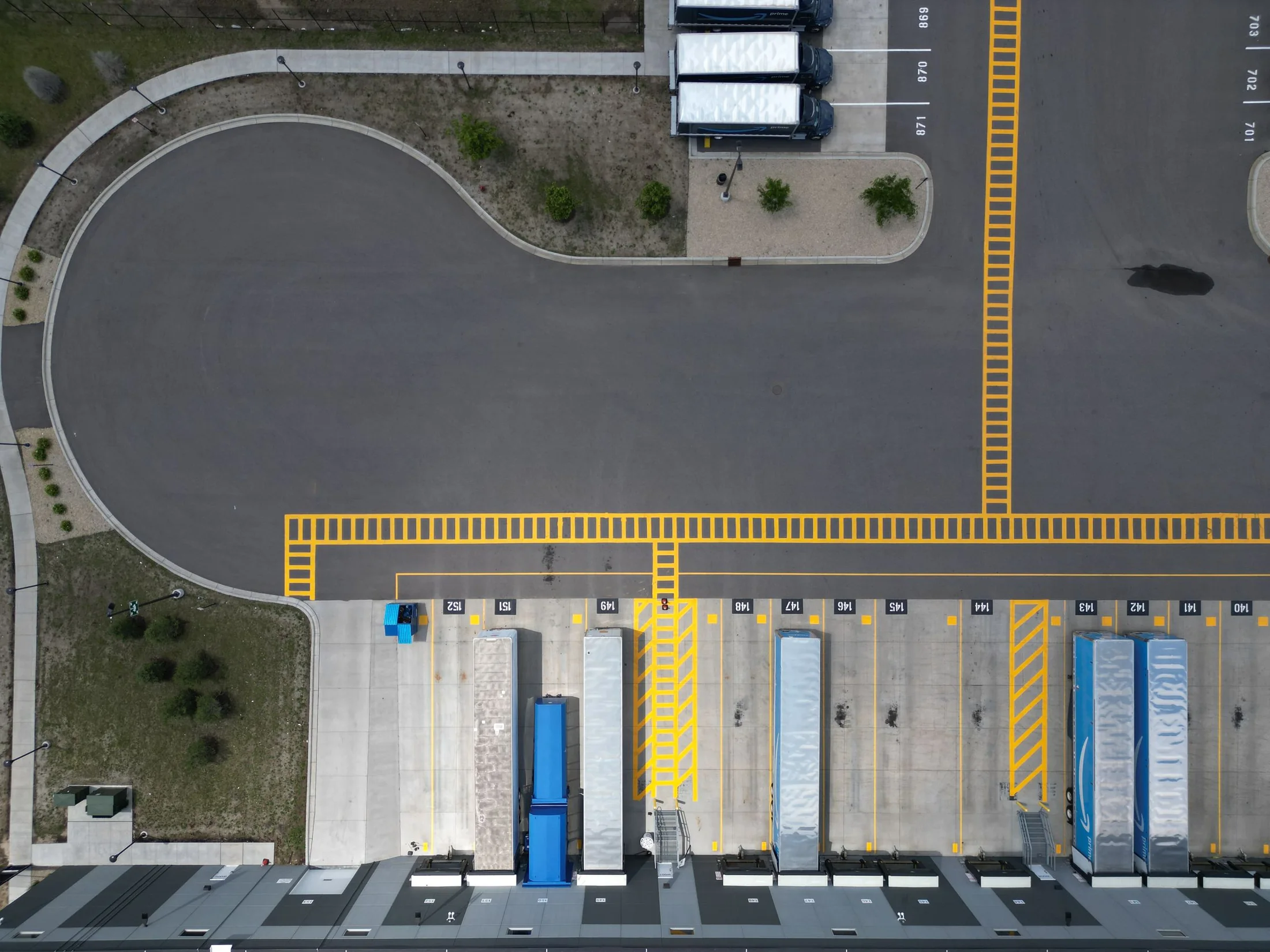 Aerial view of marked loading lanes and trailers beside a distribution building